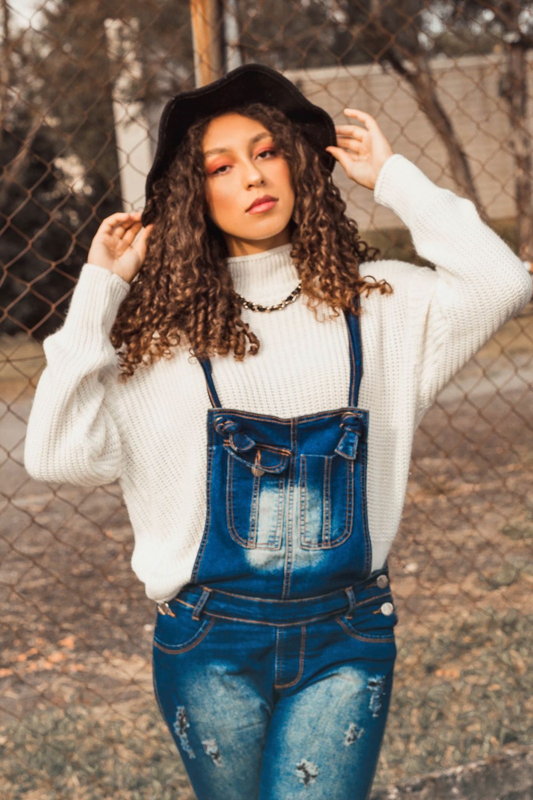 How to style plus size overalls in autumn with a cream knit sweater under denim overalls