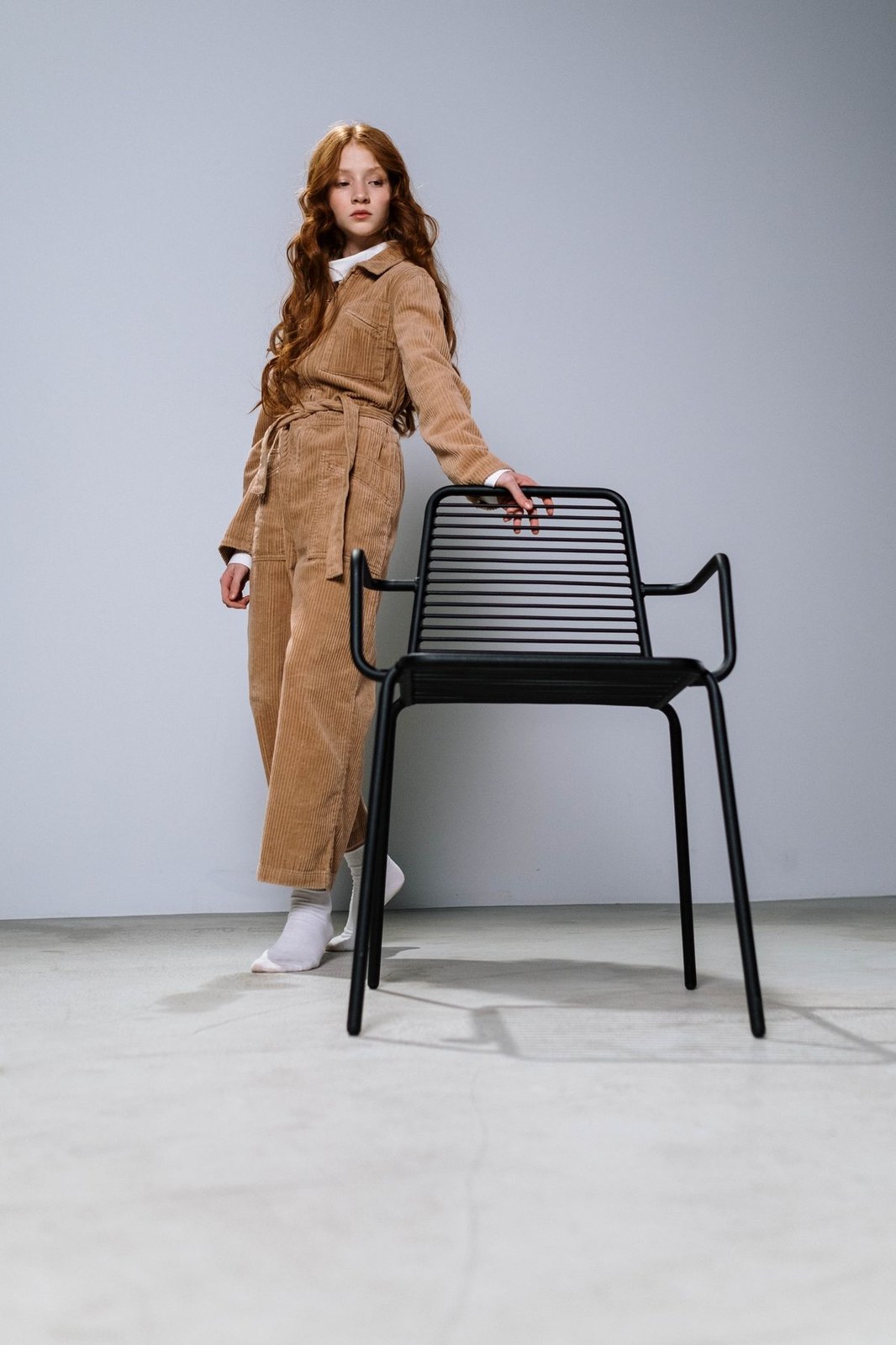 Plus size model in a camel corduroy jumpsuit styled like corduroy overalls