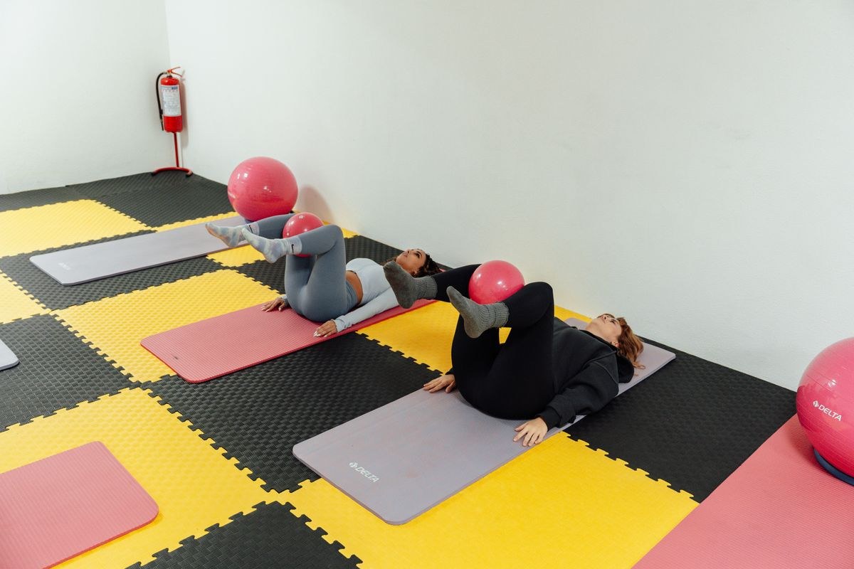 Class wearing grip pilates socks while stretching on yoga mats in a studio