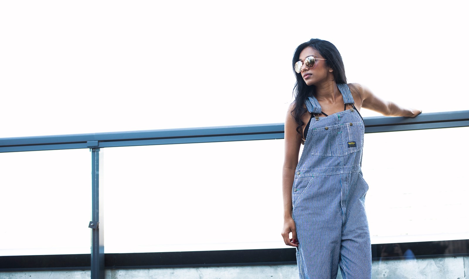 Plus size wide leg overalls with a baggy striped leg and cuffed hem worn outdoors