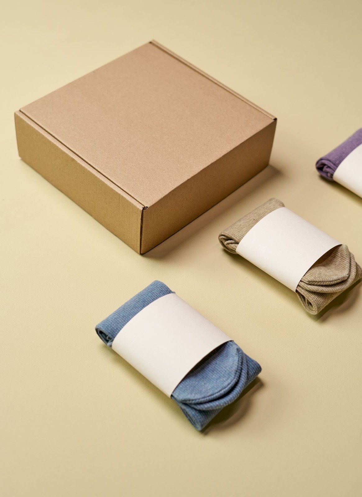 Sock multipacks with rolled pairs wrapped in paper bands beside a gift box